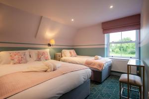 Hockwold cum WiltonBreckland Thatched Cottage的一间卧室设有两张床和窗户。