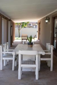 LephalaleMicasa Sucasa Guesthouse的庭院里的白色桌子和长凳