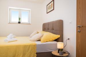 诺维格勒达尔马提亚Holiday home Figurica的一间卧室配有一张带黄色床单的床和一扇窗户。