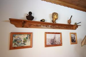 吉诺卡斯特Grandma's Home的墙上挂着照片和雕像的架子