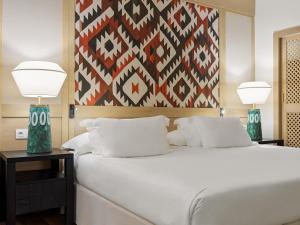 梅罗那瑞斯H10梅洛尼拉斯海滩皇宫酒店的卧室配有带两盏灯的白色床