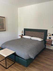 皮耶韦迪索利戈VILLA MARGHERITA的卧室内的一张带两个枕头和一张桌子的床