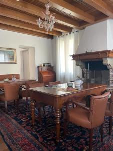 皮耶韦迪索利戈VILLA MARGHERITA的一间带桌椅和钢琴的用餐室