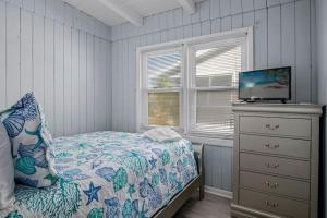 橡树岛Anchor Haven Ocean Views的一间卧室配有一张带电视的床和梳妆台。