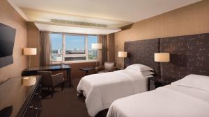 里斯本喜来登葡京酒店和水疗中心的酒店客房配有两张床和一张书桌