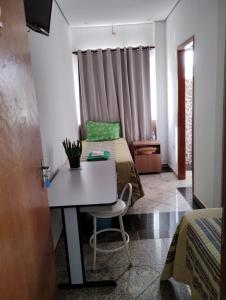 波苏斯-迪卡尔达斯Hotel Pousada Beija Flor的客房设有两张床和一张桌子及椅子