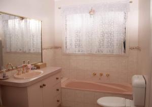 巴拉腊特Ballarat Aroma Cottage的一间带水槽、浴缸和卫生间的浴室