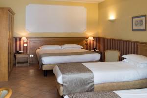 那不勒斯莱奥帕尔迪酒店的酒店客房,设有两张床和两张桌子