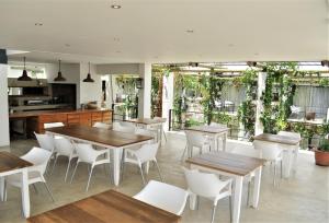 温特和克Villa Vista Guesthouse, Windhoek, Namibia的配有木桌和白色椅子的餐厅