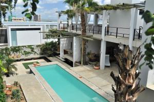 温特和克Villa Vista Guesthouse, Windhoek, Namibia的公寓大楼设有游泳池和棕榈树