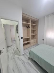 休达Family House, CENTRO CIUDAD - 3 DORMITORIOS的白色的客房配有一张床和一个衣柜