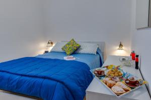 夏卡Matisé Home Relax的一间卧室配有一张蓝色的床和一盘食物
