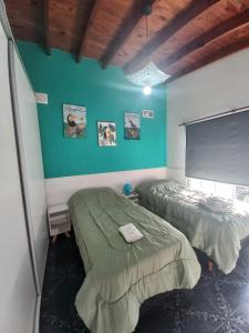 蒙特格兰德Sol y Luna B&B的一间卧室设有两张床和绿色的墙壁