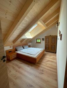 维哥迪法萨Casa Marta Dolomiti的阁楼上的卧室配有一张大床