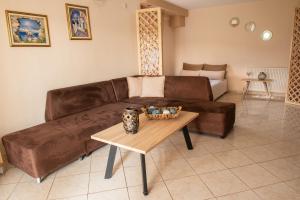 尼亚普拉莫斯Garden Suite的客厅里一张棕色的皮沙发,配有桌子