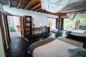曼克拉Villa Del Sol的一间卧室配有两张床和一张书桌