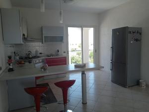 锡拉库扎Villa Gelsemium的厨房配有冰箱和红色凳子