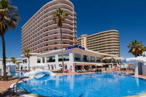 多列毛利诺斯Ibersol Torremolinos Beach的一座大型酒店,在一座建筑前设有一个游泳池