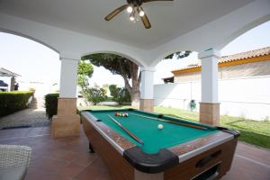 桑卢卡尔-德巴拉梅达Villa las Raices的一个带游泳池的带顶棚庭院的台球桌