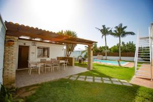桑卢卡尔-德巴拉梅达Villa las Raices的一个带桌椅的后院和一个游泳池