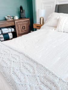 安克雷奇SunStar Alaska Bed and Breakfast LLC的卧室配有一张白色的床和木桌