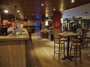 科克赛德Het Toeval的一间设有酒吧的餐厅,并在一间房间里设有凳子