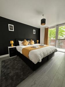 伯明翰Relocators - Parking - Central的一间卧室设有一张大床和黑色墙壁