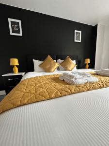 伯明翰Relocators - Parking - Central的卧室配有一张大床,配有金毛毯和枕头