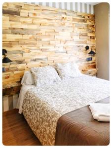塞哥维亚胡安布拉沃旅馆的一间卧室设有木墙和一张床