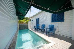 基韦斯特Just steps to Duval- Sleeps 10- Heated Pool House的一座游泳池,旁边设有两把蓝色椅子