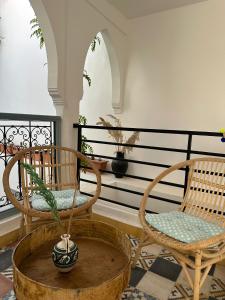 马拉喀什Dar Malwan的门廊上两把椅子和盆栽植物