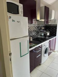 米迪克Superbe appartement à côté de la plage M'diq,Tétouan的厨房配有冰箱和洗衣机。