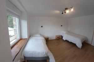 Thury-HarcourtLa Cigogne, moderne, spacieux et bien placé的一间卧室设有两张床和窗户。