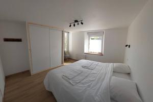 Thury-HarcourtLa Cigogne, moderne, spacieux et bien placé的白色的卧室设有床和窗户