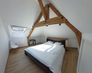 Thury-HarcourtLa Cigogne, moderne, spacieux et bien placé的卧室配有一张白色的大床,铺有木地板