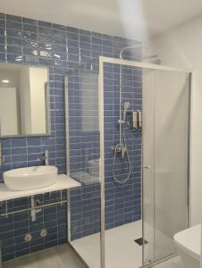 坎加斯-德奥尼斯Finca El Rabil的蓝色瓷砖浴室配有淋浴和盥洗盆