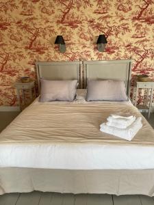 布尔日Belle Fontaine的一张带两个枕头的床和两条毛巾