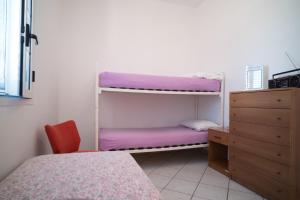 维拉诺瓦Villa ilporticciolovacanze的一间卧室配有双层床和梳妆台
