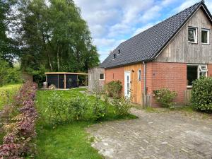 GasselteVakantiehuisje drenthe gasselterveld的前面有花园的房子