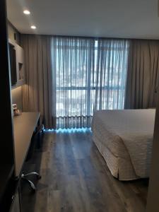 拉热斯勒卡纳德拉各斯酒店的一间卧室设有一张床和一个大窗户