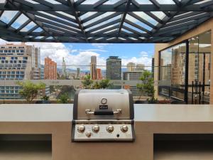 波哥大Spectacular Loft In Luxury Building的享有城市美景的柜台上的烧烤架