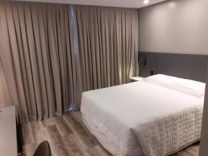 拉热斯勒卡纳德拉各斯酒店的卧室配有白色的床和窗帘