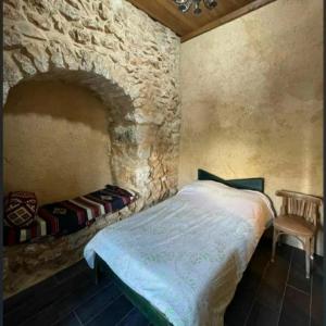 朱拜勒Beit el Deif的一间卧室设有一张床和石墙