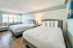 圣徒皮特海滩Thunderbird Beach Resort的酒店客房,配有两张床和椅子