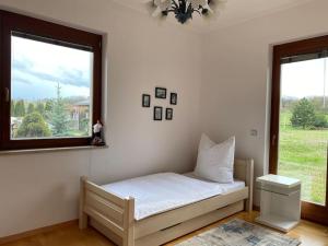 SólySzent Kard Vendégház的一张小床,位于带两个窗户的房间