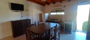 波特雷罗德洛斯弗内斯Cabañas La Gringa的厨房配有大木桌和电视。