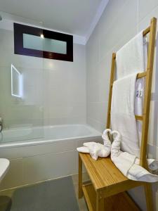 厄尔梅达诺Chalet Adosado El Medano的一间带毛巾架和浴缸的浴室