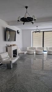 锡盖图马尔马切伊Casa Florus的客厅配有白色家具和吊灯。