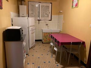 Ayzac-OstVilla At-Arcos的厨房配有桌子、冰箱和水槽