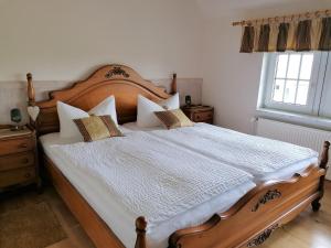 华法林Landtraum im Traumland Mecklenburg的一间卧室配有一张带枕头的大型木制床。